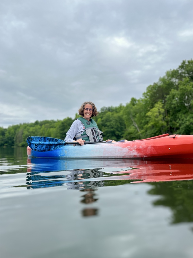 Kate kayaking on a calm lake